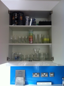 Glasses and drinks awaiting a fridge space (and a first aid box at the very top)